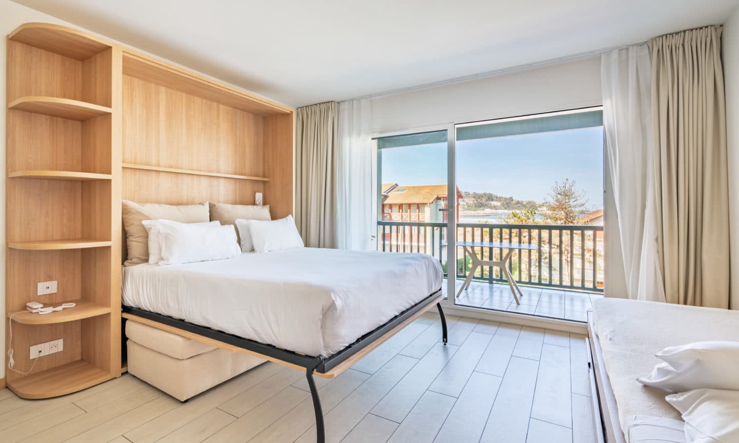 Chambre avec lit escamotable et vue sur la mer au loin